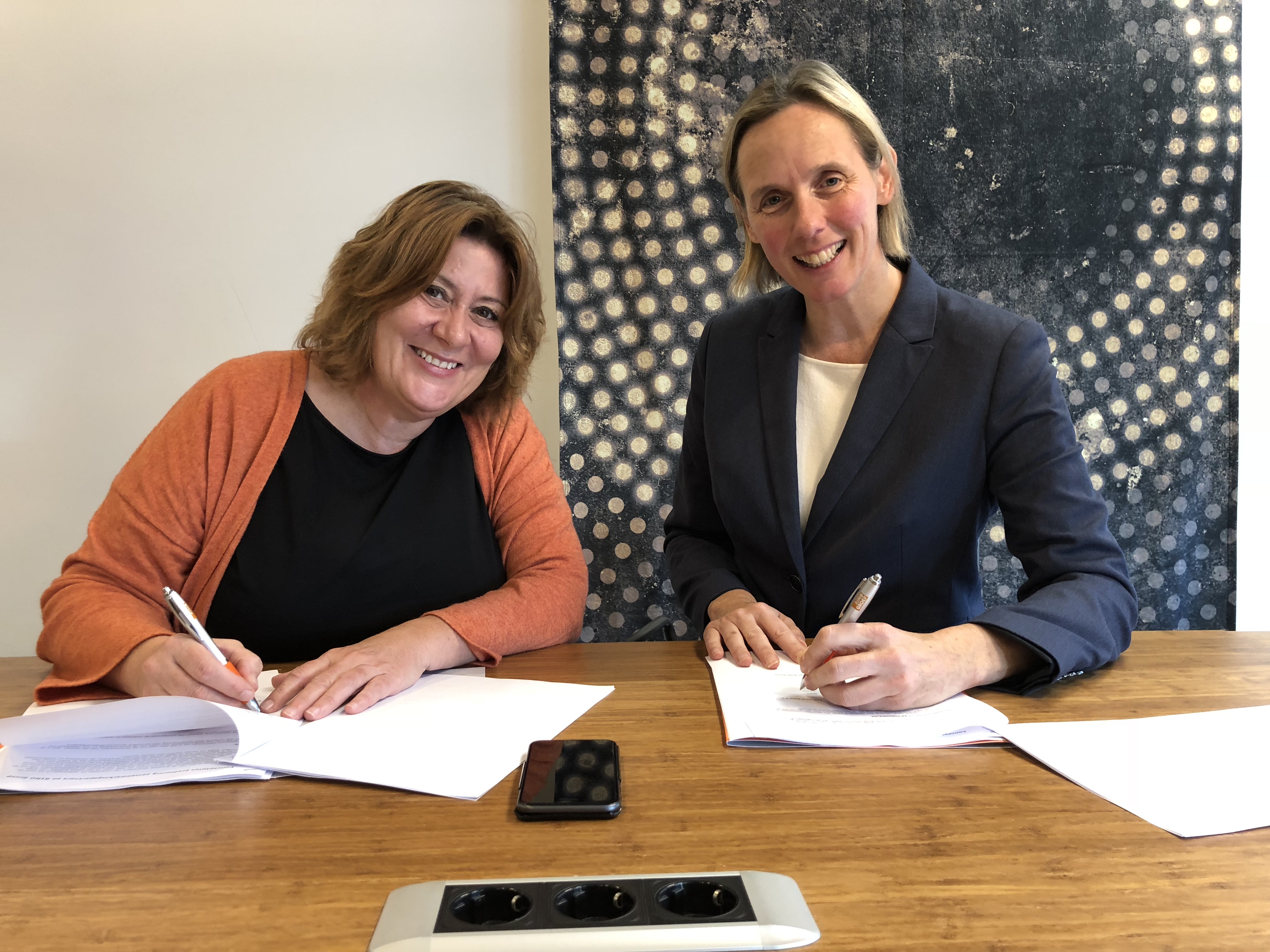 Hedda van 't Land en Marjet van Baggum ondertekenen de overeenkomst tussen de RINO Groep en De Borg